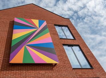 An image showing the geometric pattern artwork fixed to the side of the student accomodation building. Photo by Oliver Cameron-Swan/Meadow Arts