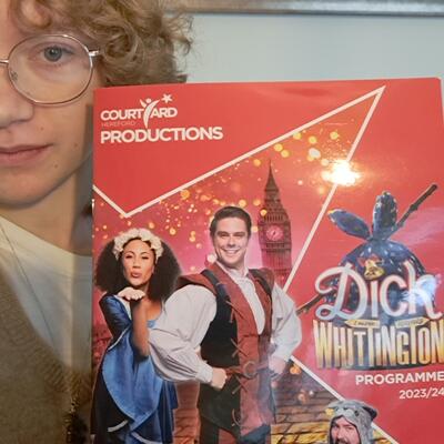 Alice Drury holding a programme of Dick Whittington