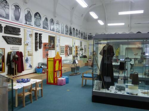 An image showing museum exhibition with items including clothing in glass cases