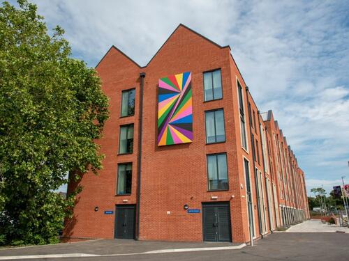 An image showing the geometric pattern artwork fixed to the side of the student accomodation building. Photo by Oliver Cameron-Swan/Meadow Arts