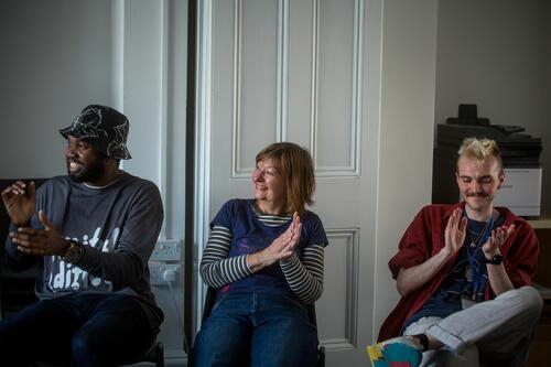 Three volunteers at Ledbury Poetry clapping and smiling