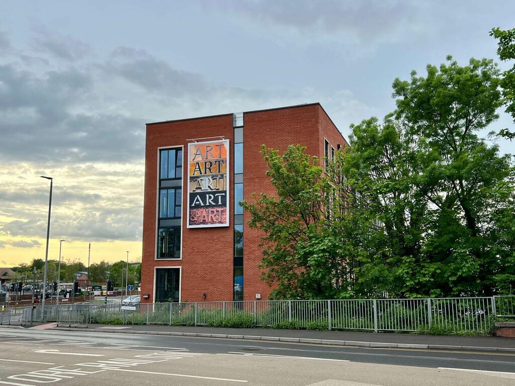Image showing the second artwork attached to the side of a four storey red-brick building. This piece has the word 'art' four times in differing typeface styles.