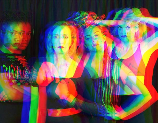 A disorted image of four women in poses of strength and power.