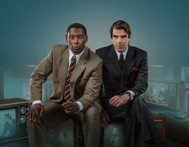 An image of two men, the actors David Harewood and Zachary Quinto, sitting side by side wearing suits and looking directly out to the camera. 